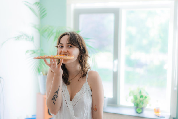 女人在家跳舞，吃整个披萨图片下载