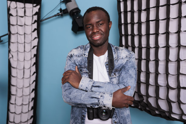 制片人双臂交叉站在专业摄影设备旁图片下载