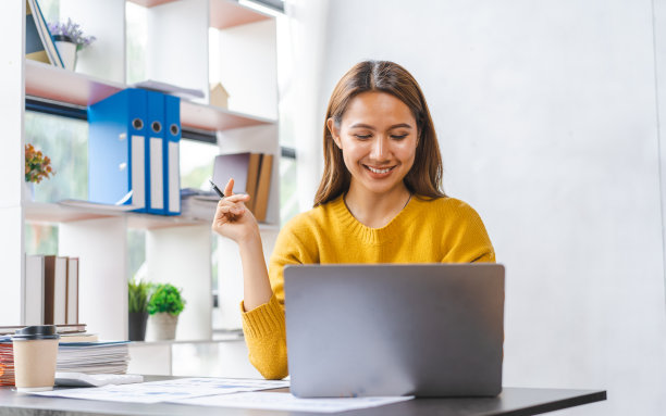 微笑的亚洲年轻学生在网上学习专业知识或准备考试，通过笔记本电脑在线视频通话。图片下载