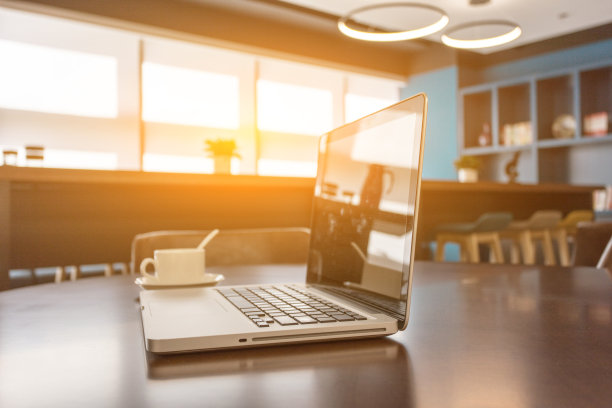 现代企业内部共享的休息室空间，木桌，扶手椅，咖啡和笔记本电脑图片下载