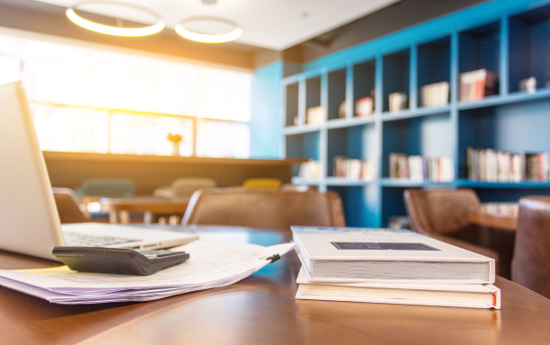 现代办公区域的木桌上放着笔记本电脑和书籍图片下载