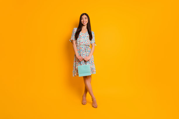 全身形象照片的年轻漂亮的女士在时尚的服装服装隔离在黄色的背景图片下载