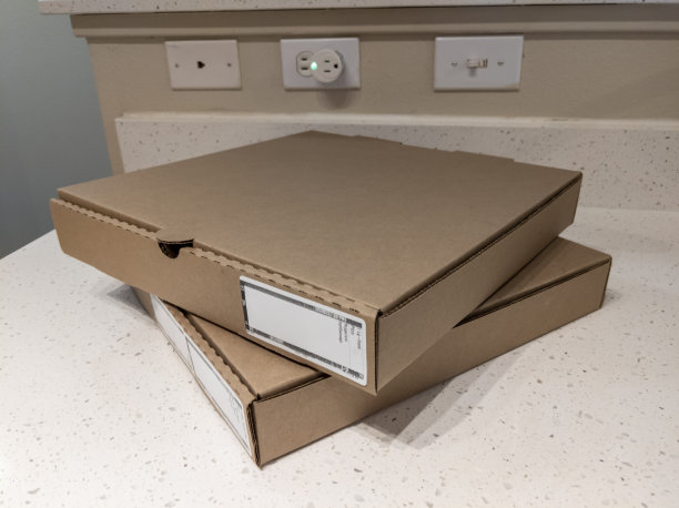 近距离观察两个纸板披萨盒在厨房柜台顶部图片下载