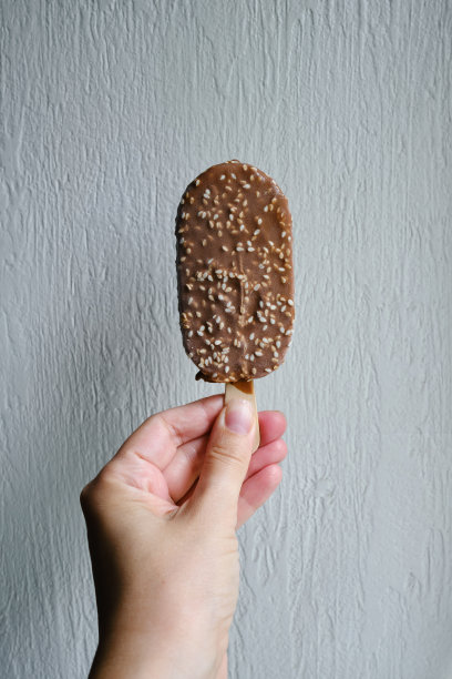 在浅色的背景上浇上巧克力冰淇淋。天然冰淇淋特写。夏日香甜可口的凉拌甜点。传统乳制品图片下载