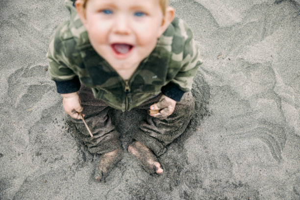 婴儿完全覆盖在沙滩上的沙子图片下载
