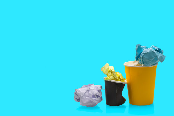 被揉皱的纸球和一次性咖啡纸杯分开。图片下载