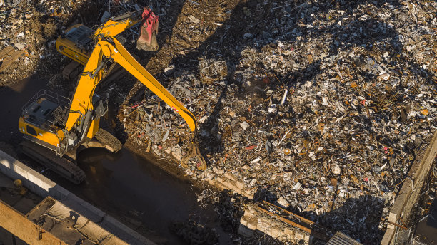 废金属搬运工将废金属搬运到废料场。图片下载