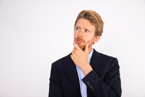 沉思的年轻商人的肖像，手放在下巴上图片下载