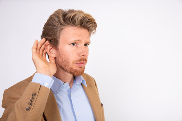 特写的年轻商人站在与手在耳朵图片下载