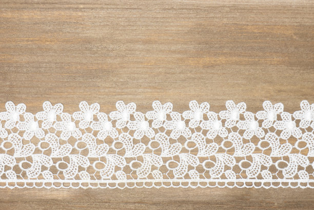 白色花边与花在棕色木制背景水平。温柔与粗糙的对比图片下载