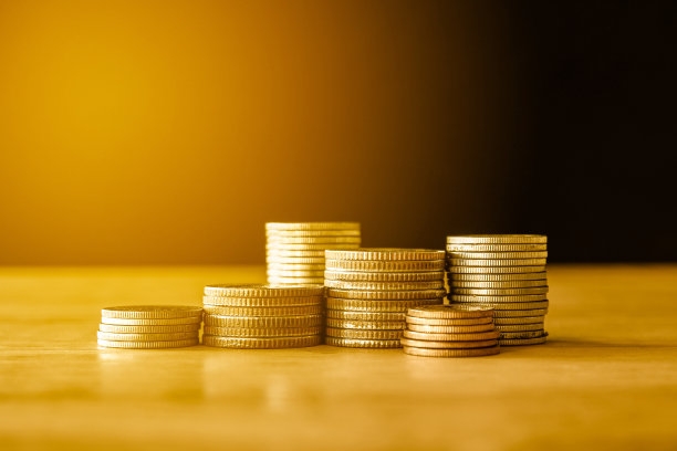 一堆堆的金币硬币在黑色的背景，商业和节约金钱的概念。图片下载