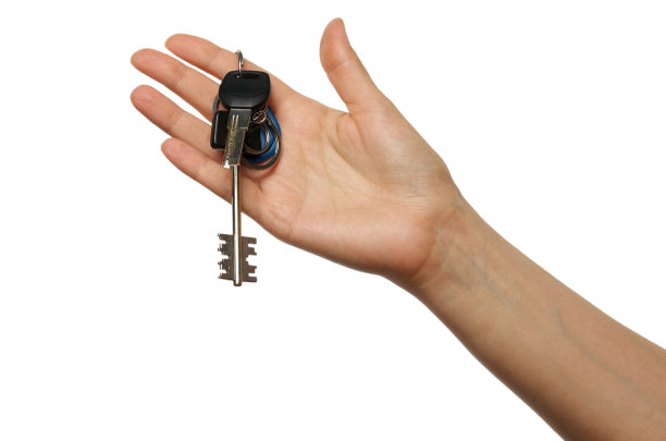 女人手拿钥匙。隔离在白色背景与剪切路径图片下载
