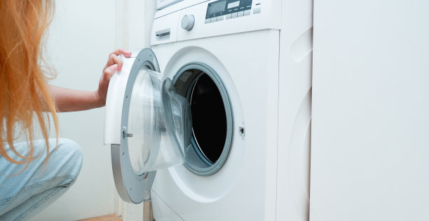 洗衣服。一个女人正在给洗衣机装东西。光内部。特写镜头。图片下载