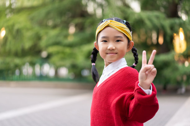 小女孩做着和平的手势图片下载