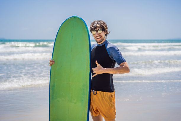 在海滩上拿着冲浪板的冲浪者图片下载