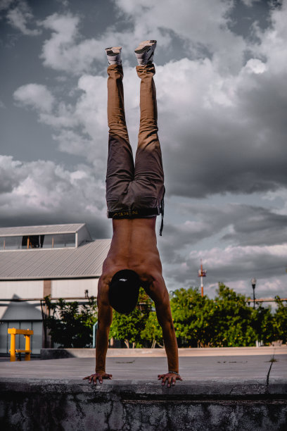 拉丁裔运动男孩在公园里倒立。一个男孩在公园里做体操。一个拉丁人在公园里以极端的方式锻炼图片下载