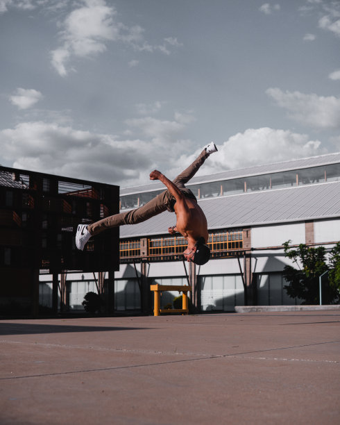 一个皮肤黝黑的拉丁裔小男孩正在练习一个极端的霹雳舞动作。西班牙男子正在练习特技。图片下载