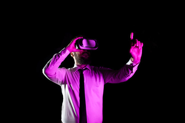 男性专业佩戴虚拟现实头盔手势和享受模拟器。轻落在商人呈现现代科技和使用未来小玩意。图片下载