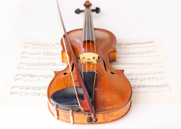 巴洛克小提琴和巴洛克弓与乐谱在背景图片下载