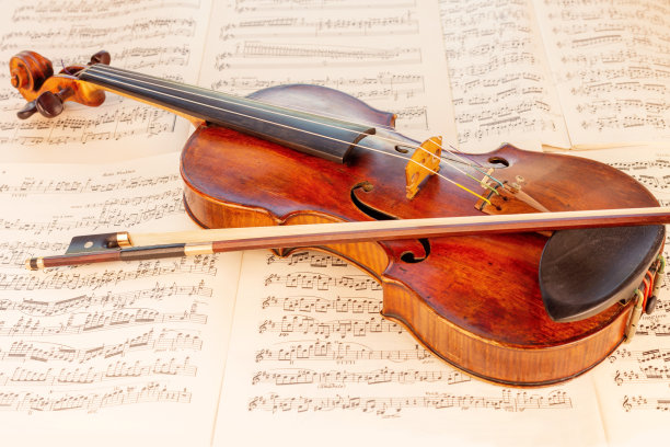 古老的古典小提琴和弓与乐谱在背景图片下载