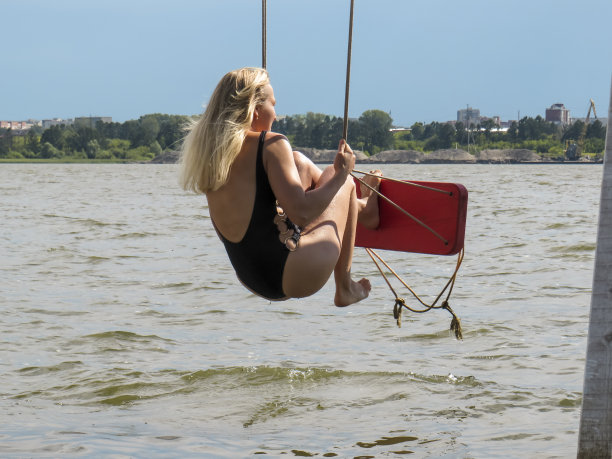 金发美女穿着泳装在沙滩上荡秋千图片下载