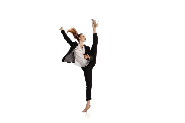 普遍的员工。年轻的女孩在商业西装跳舞在白色背景上孤立的高跟鞋。情感、财务、抱负、商业、工作理念。图片下载