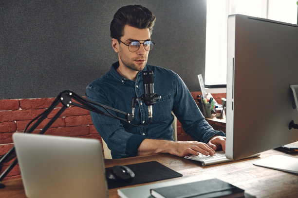 自信的年轻人在录音棚用电脑和麦克风录制播客图片下载