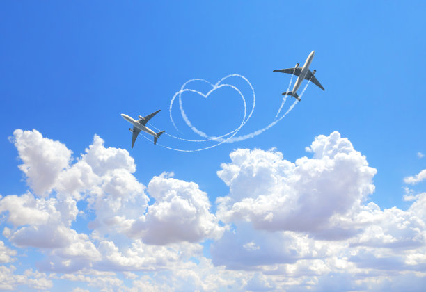 横向的自然背景，两架飞机在天空中画出一颗心。心形飞机的飞行路线图片下载