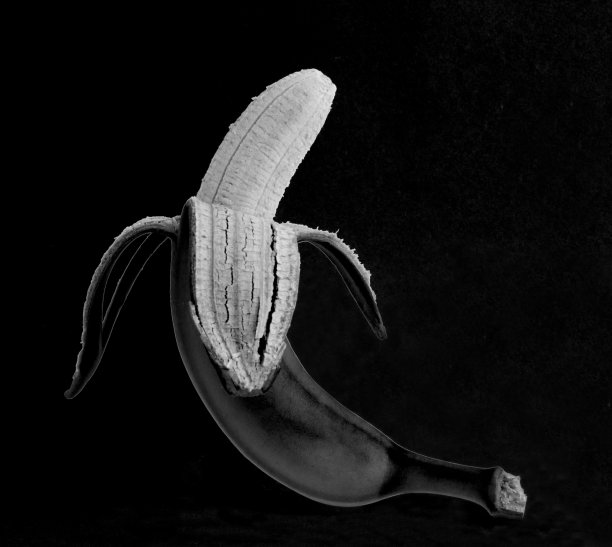 黑色背景上剥皮香蕉的特写图片下载