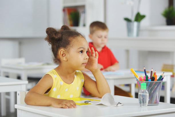 一个黑人女孩在教室里专心地听老师讲课图片下载