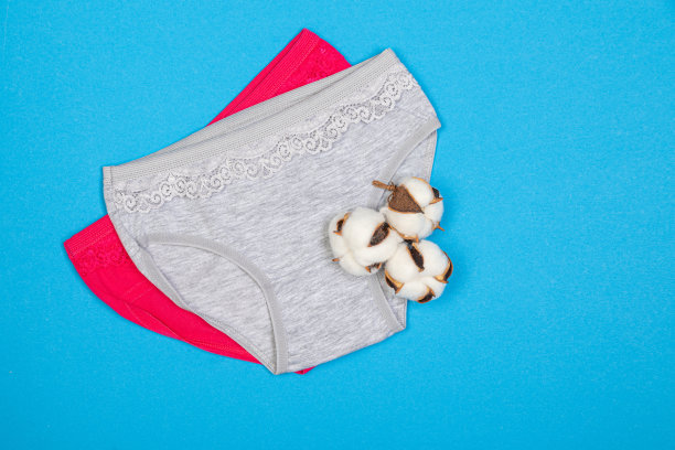 蓝色背景的童装内裤。柔软布料的儿童衣服。女生内裤和棉花图片下载