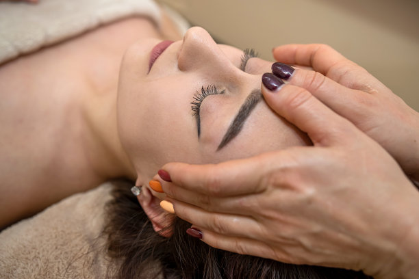 最好的按摩师用轻柔的双手按摩头部和脸部，适合面部最好的按摩对象。图片下载