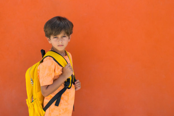 一个7岁孩子的肖像与书包和学校用品。图片下载