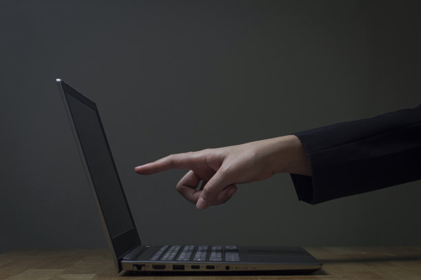 女人在黑暗中使用笔记本电脑，屏幕发出亮光。图片下载