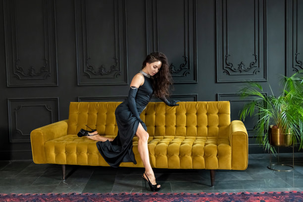穿黑衣服的女人站在黄色的沙发上图片下载