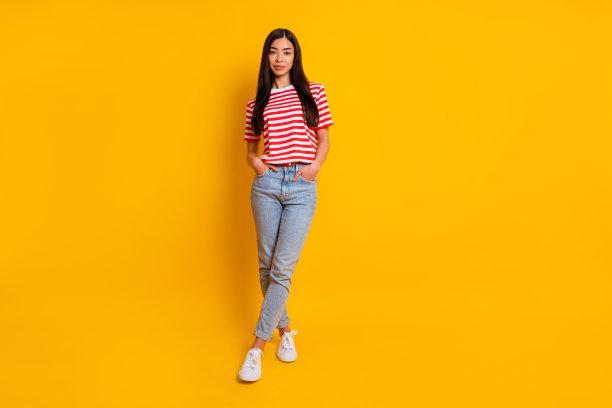 全身肖像的年轻女孩黑色的头发把双手口袋穿红白条纹t恤孤立在黄色的背景色图片下载