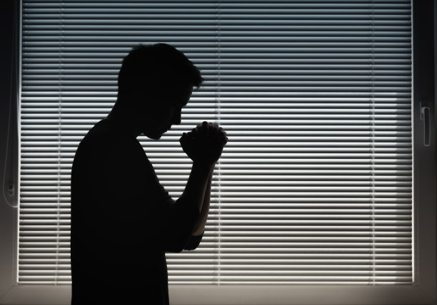 一个人在窗边祈祷。图片下载