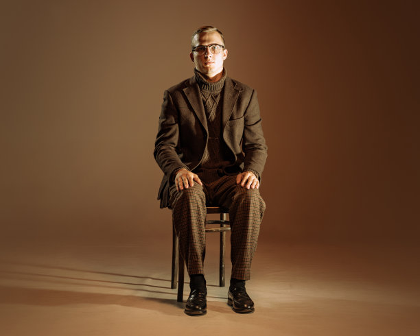 复古风格肖像的年轻人，作家和旅行者穿着复古风格的衣服孤立在深棕色的背景。商业、艺术、时尚理念图片下载