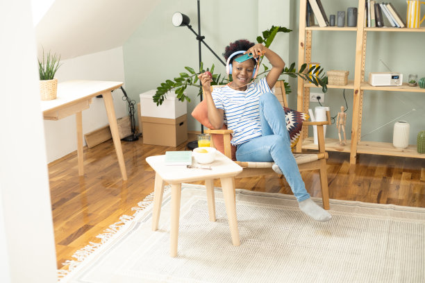 非洲年轻女子一边吃苹果一边欣赏音乐图片下载