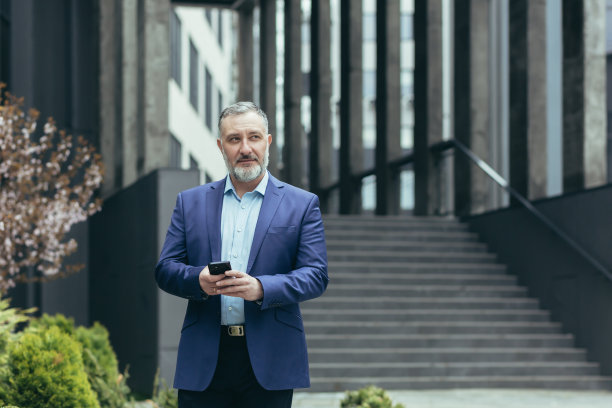 成功的高级投资者办公楼外电话，商人西装革履图片下载