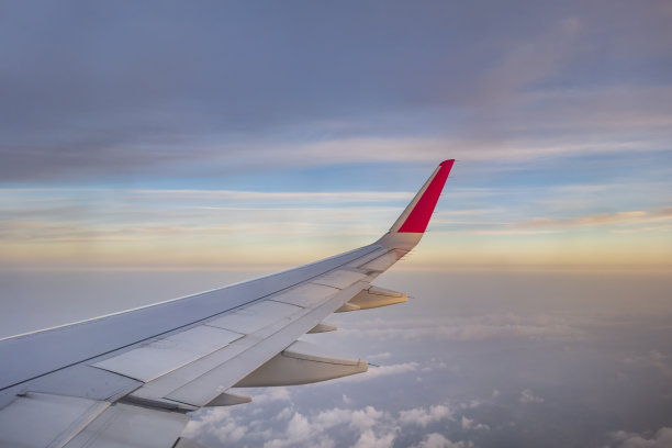 飞机的翅膀在天空的云上面飞行图片下载