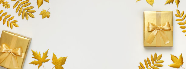 平铺秋日假日概念。金色的礼物或礼品盒与丝带和金色的秋叶在浅灰色的背景俯视拷贝空间。惊喜，祝贺，生日，贺卡图片下载