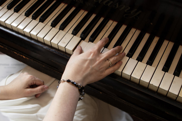 穿着白色长裙的女孩正在弹钢琴图片下载