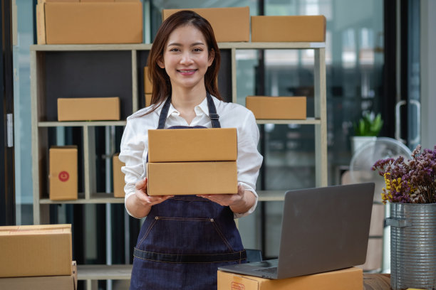 在线销售女企业主接收订单，并将产品与盒子运送给客户。网上中小企业经营理念图片下载