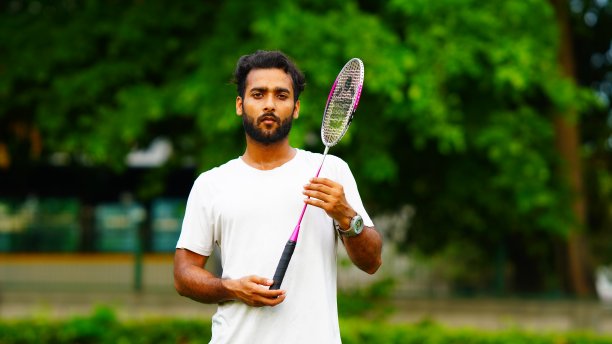 羽毛球运动员手持羽毛球拍照片的肖像图片下载