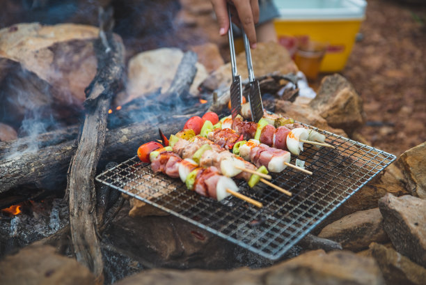 近距离烧烤，烧烤或牛排肉烤自然火露营气氛。在山上露营放松时光。假日概念活动。图片下载