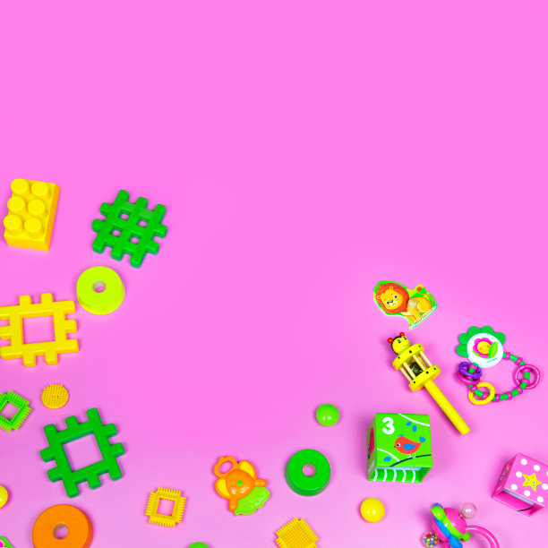 在粉红色的背景上平铺塑料和木制的儿童玩具。框架背景与空白空间，复制空间，文本空间图片下载