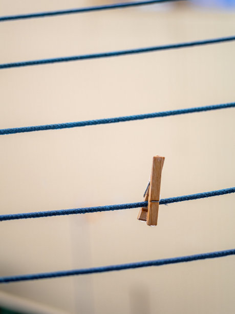 晾衣绳上的木制晾衣夹，雨后挂有水滴。图片下载