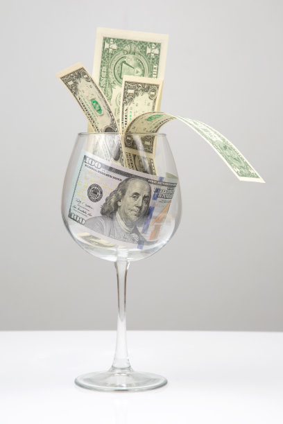空酒杯里的钱。在线业务出售。贸易业务中的财务成功。图片下载