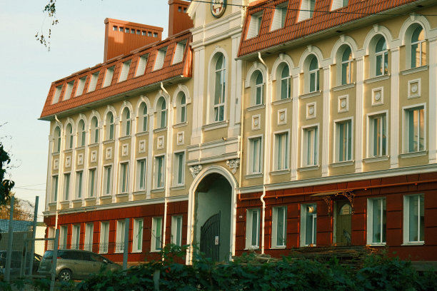 城市里漂亮的红黄相间的建筑。城市街道上的砖墙橙黄色政府大楼。美丽的多层红橙色砖建筑图片下载